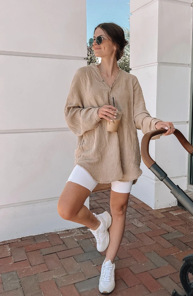 Oversized beige top paired with white biker shorts. Perfect for casual outings, featuring a v-neckline and long sleeves.