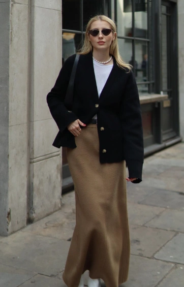 A stylish outfit featuring a black blazer and a camel-colored maxi skirt, perfect for casual or semi-formal occasions.