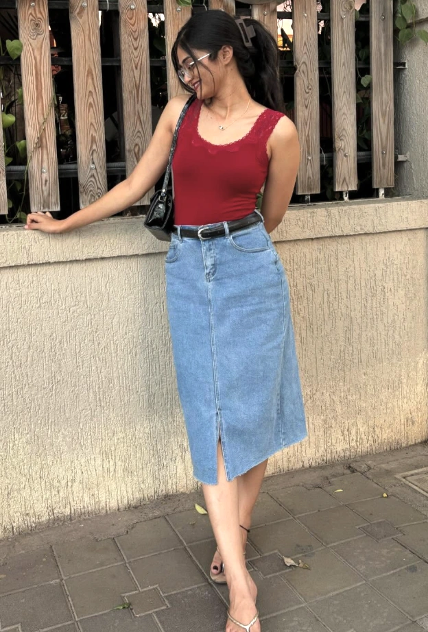 Casual outfit featuring a red lace-trimmed tank top and a light blue denim midi skirt with a front slit. Perfect for summer outings.