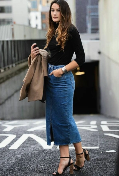 A stylish denim pencil skirt featuring a front slit, paired with a fitted black top, perfect for casual outings.