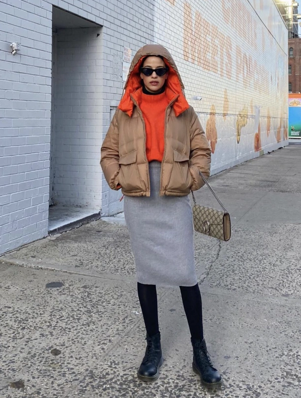 Grey ribbed pencil skirt paired with an orange turtleneck and brown puffer jacket, ideal for casual outdoor outings.