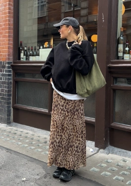 Casual leopard print maxi skirt paired with a black oversized sweatshirt and sneakers, suitable for relaxed outings or brunch.