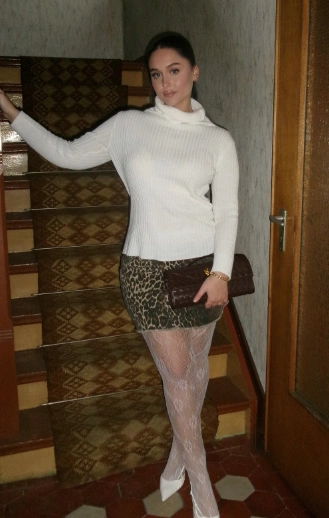 A leopard print mini skirt paired with a cozy white cowl neck sweater, ideal for casual outings or evening events.