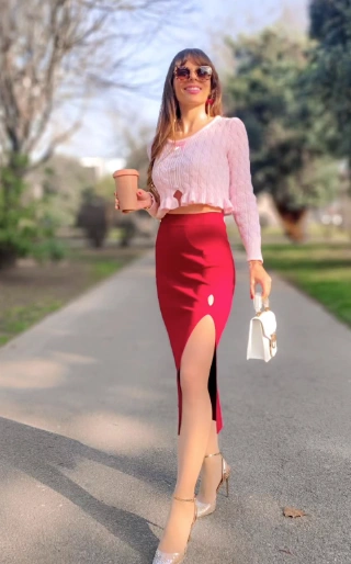 Slim-fit red pencil skirt featuring a thigh-high side slit, paired with a light pink ribbed sweater; perfect for casual outings or brunch.