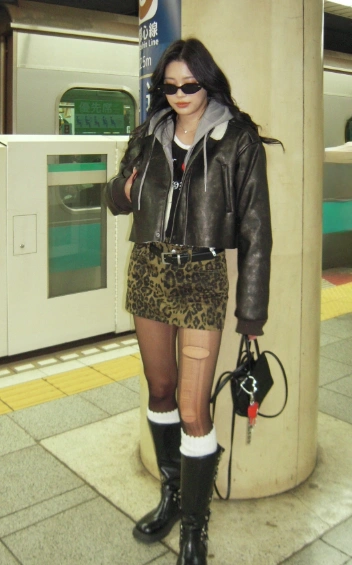 Stylish leopard print mini skirt in earthy tones, paired with a cropped leather jacket, ideal for casual outings or nightlife.