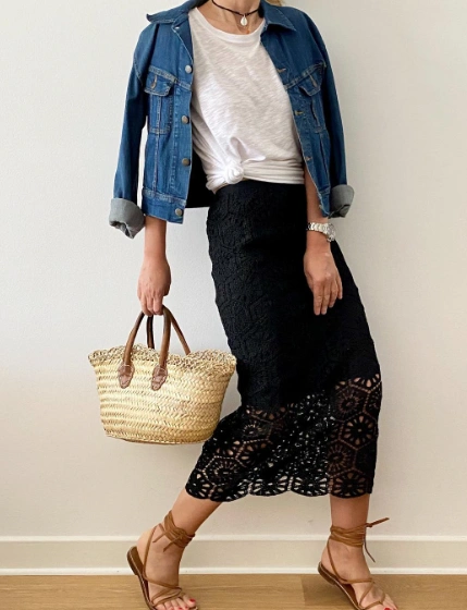 Black crochet maxi skirt paired with a white knotted tee and denim jacket, styled casually for daytime outings.
