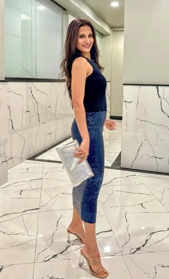 A fitted black top paired with a stylish blue pencil skirt. Suitable for formal occasions, featuring a sleek silhouette and shiny accents.