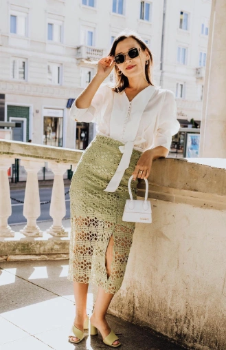 Mint green crochet skirt with a high slit and intricate pattern, paired with a white blouse, perfect for casual outings or day events.