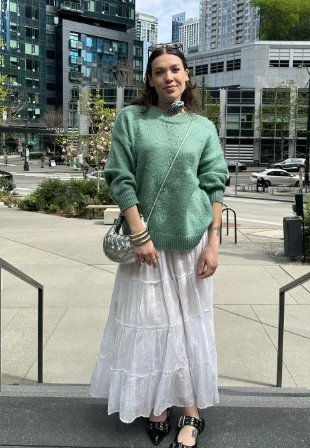 A casual outfit featuring a white tiered maxi skirt and a mint green oversized sweater, perfect for spring outings.