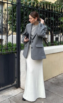 A stylish outfit featuring a gray blazer over a white maxi skirt. The look is sophisticated and suitable for formal occasions.