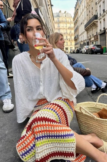 Bohemian crochet skirt in multicolor stripes paired with a casual white oversized top, perfect for outdoor gatherings or summer outings.