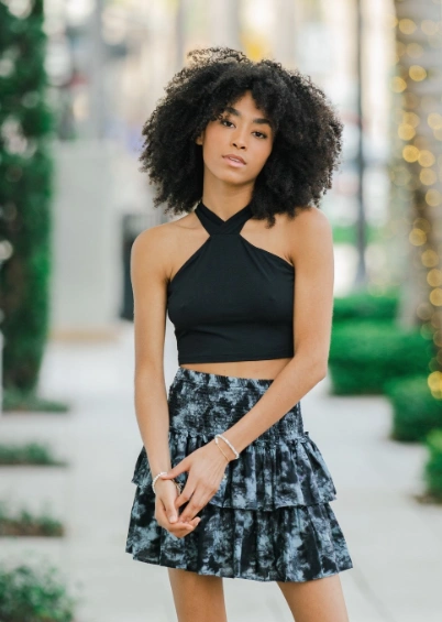 Black halter top paired with a tiered ruffle skirt featuring a subtle floral pattern, perfect for casual outings or summer events.
