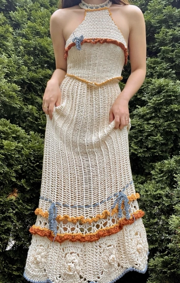 A cream crochet maxi skirt featuring colorful trim, a halter neckline, and a fitted silhouette, perfect for casual summer outings.