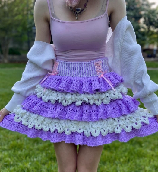 A playful crochet skirt featuring lavender and white ruffles, ideal for casual outings or summer events.