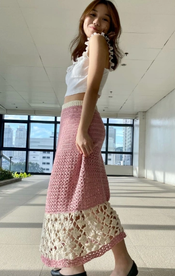 A long crochet skirt featuring blush pink and ivory colors, with a bohemian style, perfect for casual outings.