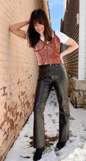 Black leather pants paired with a rust-colored cropped top, creating a stylish, casual look perfect for everyday outings.