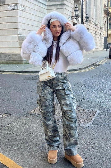 A chic outfit featuring a fluffy white cropped jacket, gray camo cargo pants, and tan Ugg boots, perfect for casual outings.