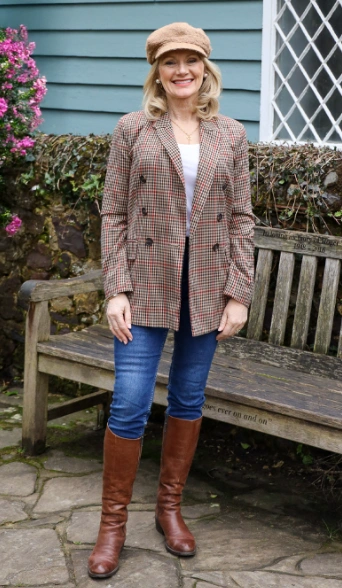 Stylish houndstooth blazer paired with fitted jeans and tall brown leather boots, perfect for smart-casual occasions.