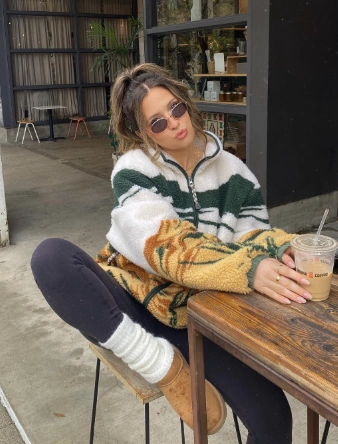 A casual zip-up fleece pullover in cream, green, and orange, paired with black leggings and cozy Ugg boots, ideal for relaxed outings.