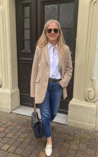 A stylish beige blazer over a white button-up shirt paired with blue straight-leg jeans, perfect for casual outings or brunch.