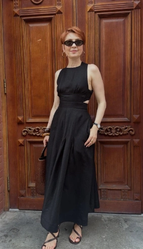 Sleeveless black A-line maxi dress featuring a fitted waist, cut-out details, and a flowing skirt; perfect for formal occasions.