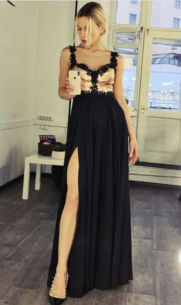 Long black evening gown with a rose gold bodice, featuring a plunging neckline and a high slit, ideal for formal occasions.
