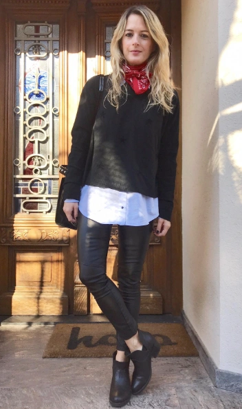 Casual black oversized sweater layered over a white button-up shirt, paired with shiny black leggings and ankle boots. Suitable for winter work events.