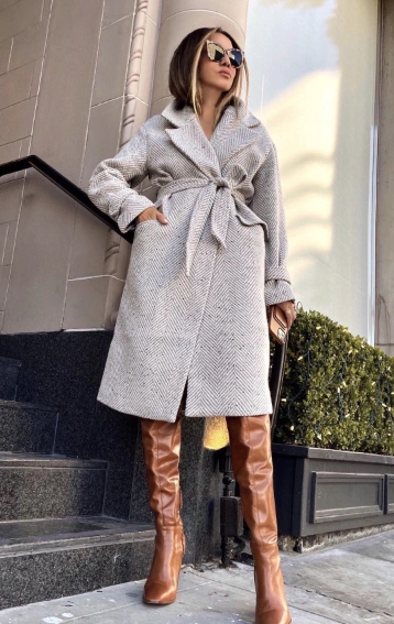 A stylish houndstooth wrap coat in gray, paired with brown knee-high boots. Perfect for winter outings or casual work events.