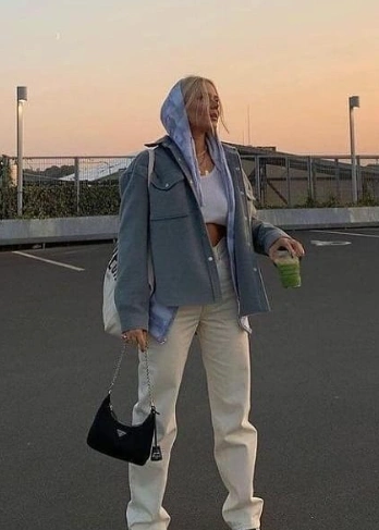 Oversized denim jacket in light blue with a hood, paired with white wide-leg pants; casual style suitable for everyday outings.