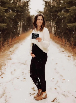Maternity outfit featuring a white sweater and black leggings, ideal for casual winter outings with a relaxed fit and long sleeves.