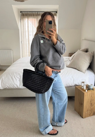Casual grey maternity sweatshirt paired with relaxed denim jeans, featuring long sleeves and a round neckline, perfect for everyday wear.