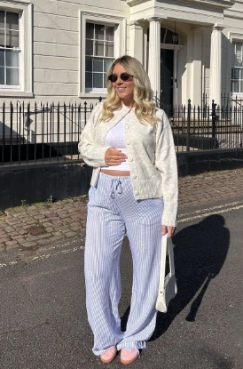 Light blue and white striped wide-leg pants paired with a white cropped cardigan, ideal for casual outings or relaxing at home.