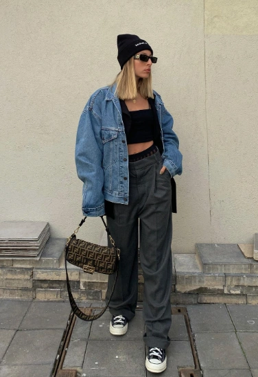 Casual winter outfit featuring a blue denim jacket, black crop top, gray wide-leg pants, and a black beanie, perfect for urban outings.