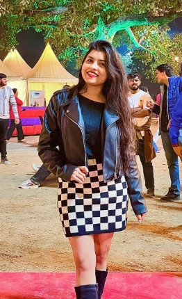 Woman in a black leather jacket and a checkerboard mini skirt. Casual style, perfect for a concert or night out.