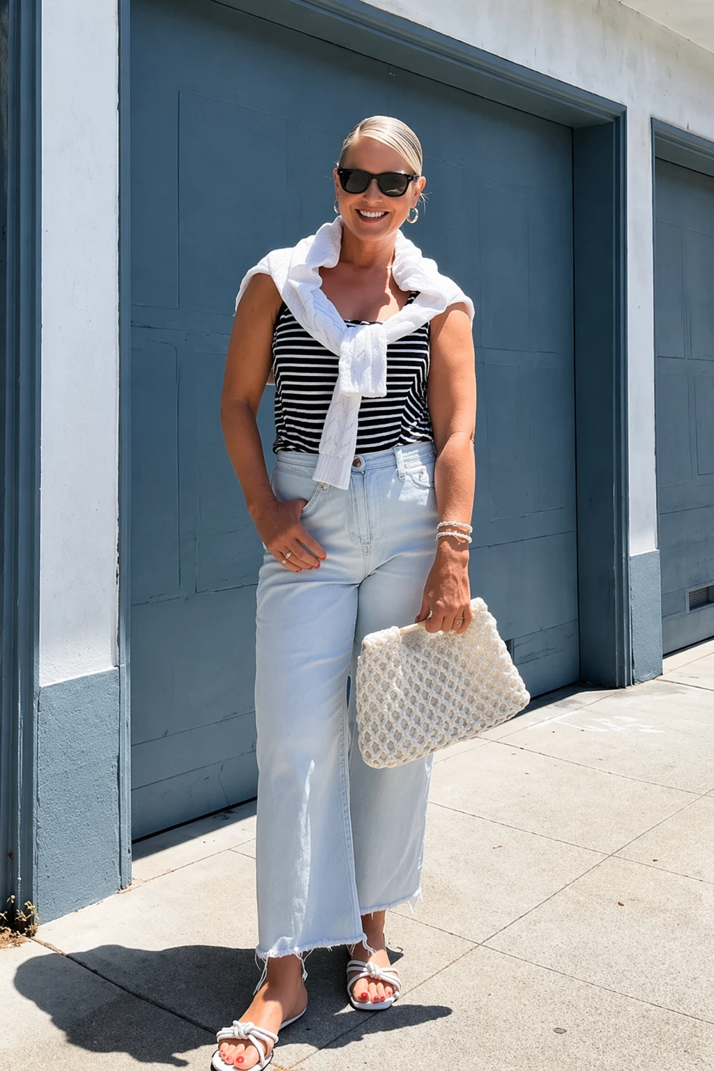 Striped tank top with white sweater, light blue wide-leg jeans, casual style, perfect for summer outings or brunch.