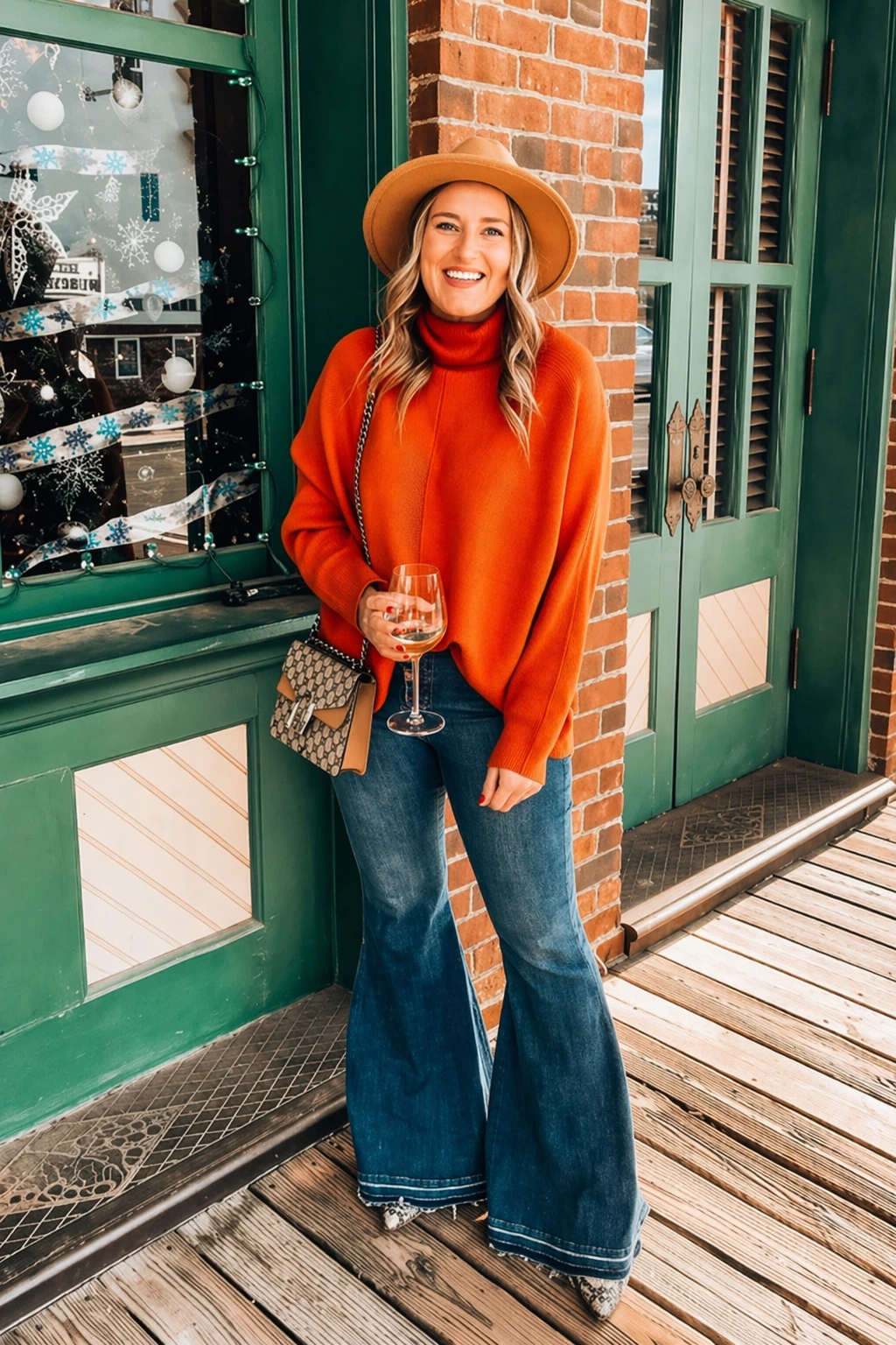 A casual outfit featuring an orange turtleneck sweater and blue flare jeans, perfect for a relaxed social gathering.