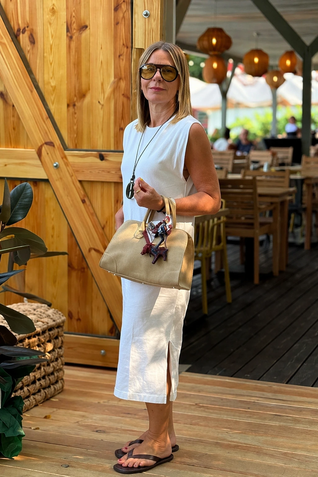 A sleeveless white linen midi dress featuring side slits, perfect for casual summer outings or brunches.