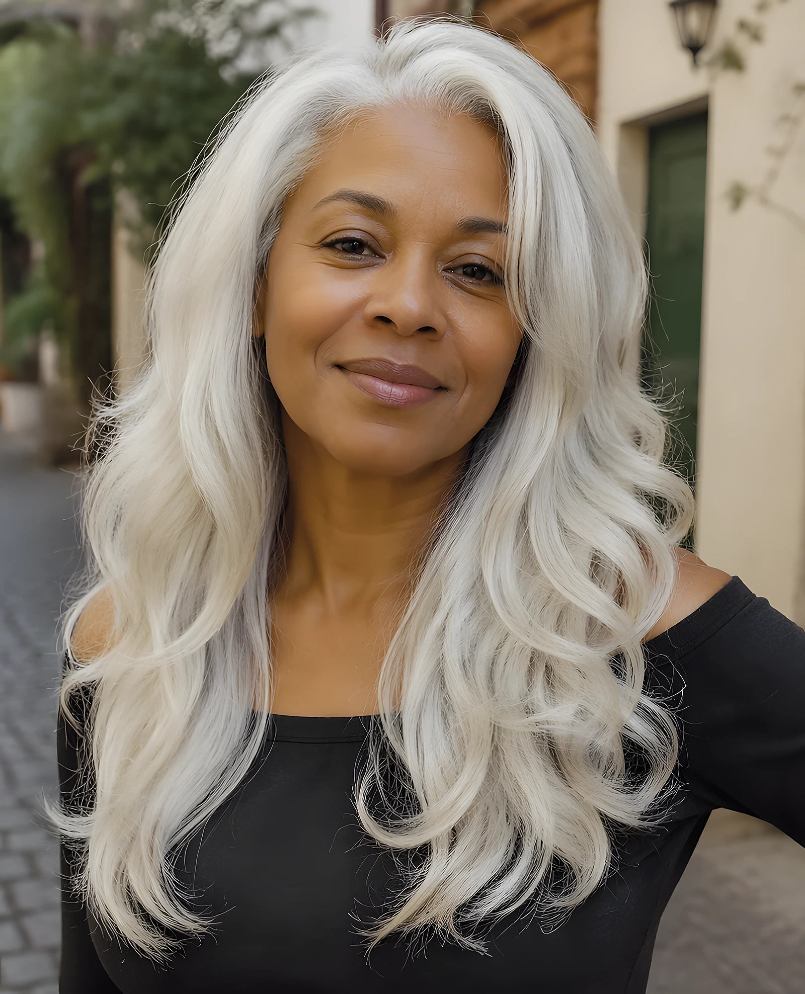 Older woman with long, bright silver hair, loose flowing waves, and a soft center part framing her face.