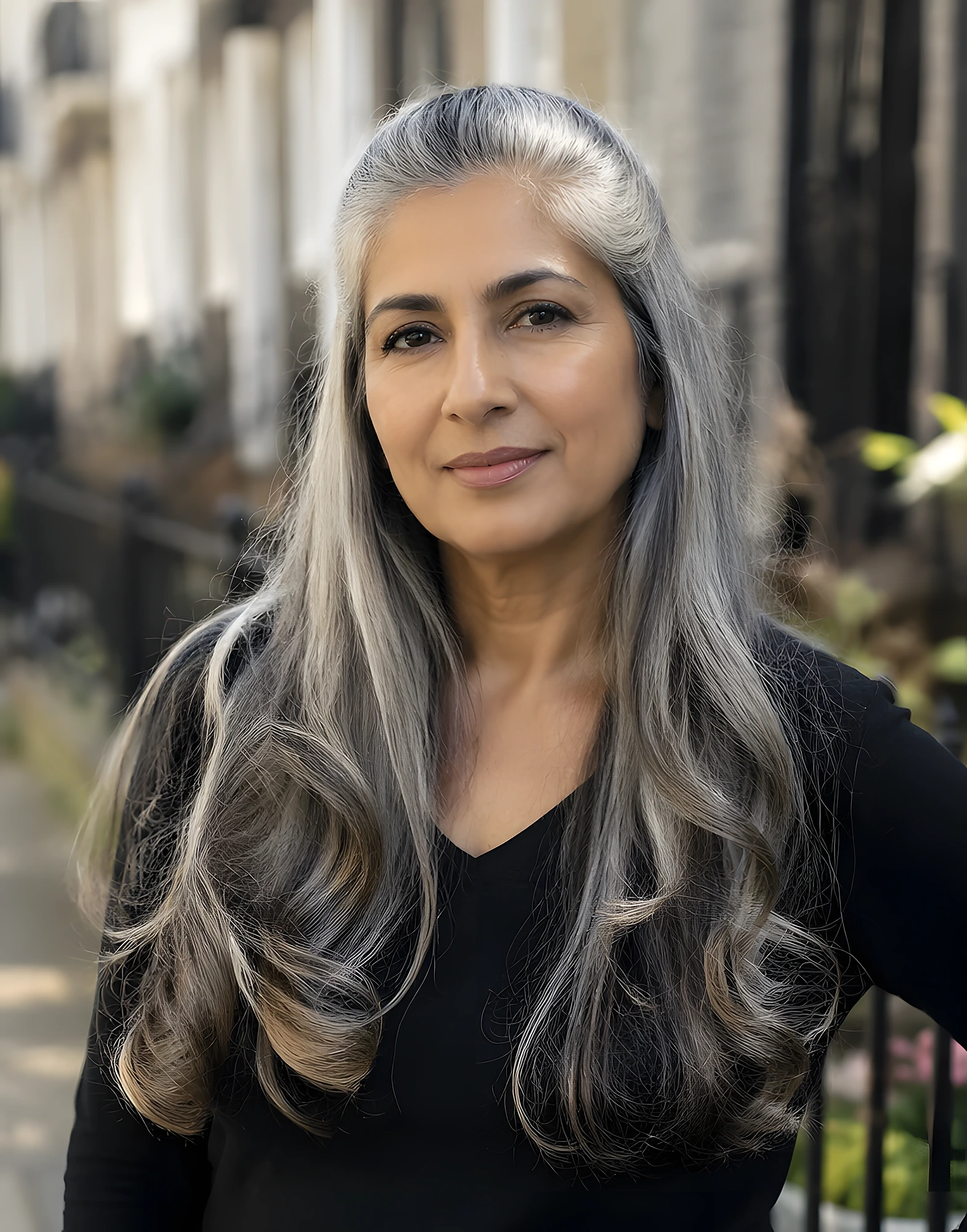 Long silver-gray hair styled in loose waves, a middle part, and glossy ends that fall well past the shoulders.