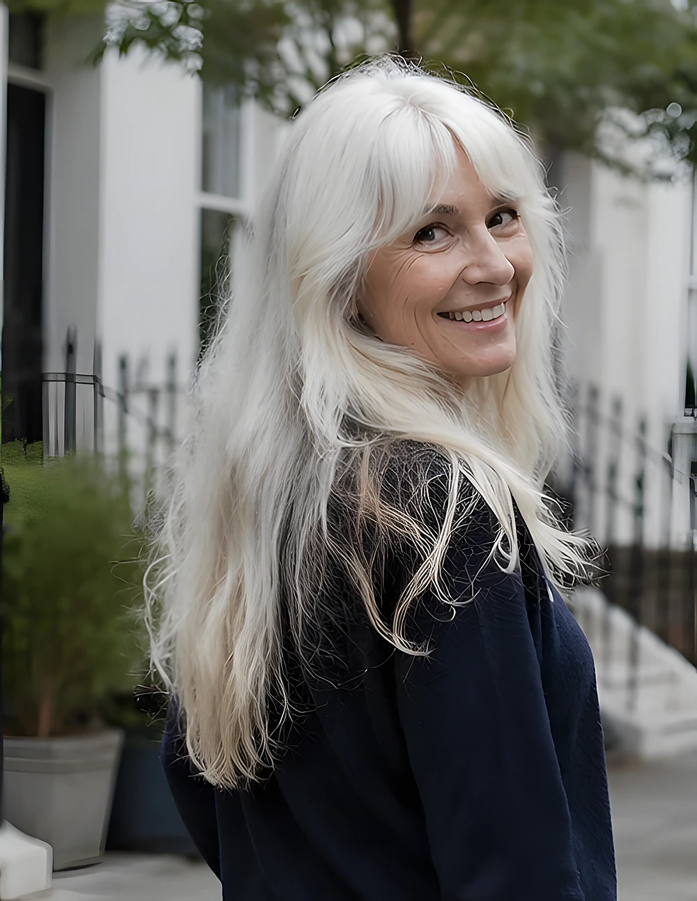 Long platinum-blonde hair worn down with airy layers, soft movement, and lightly feathered ends around the shoulders.