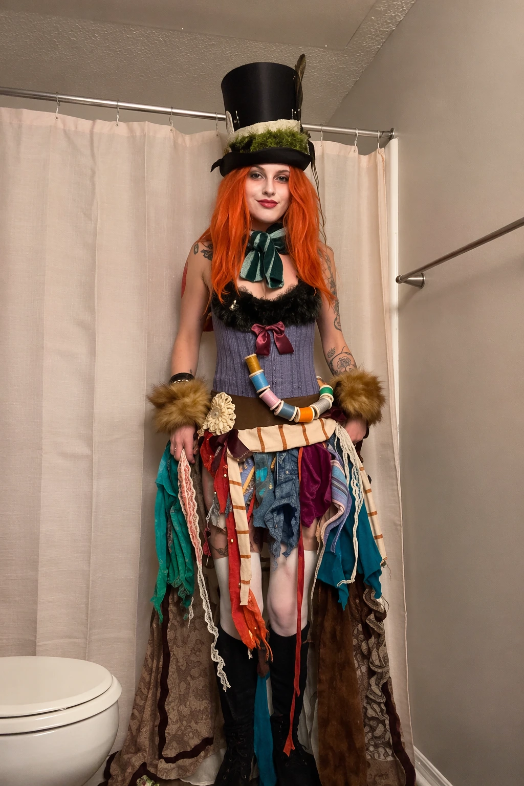 Tall black top hat, bright orange wig, velvet bow, and chaotic patchwork skirt with furry cuffs and ribbons.