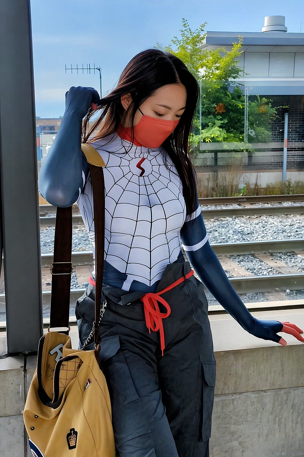 Woman in white web-pattern top, navy sleeves, red mask, cargo pants, and tan shoulder bag by train tracks.