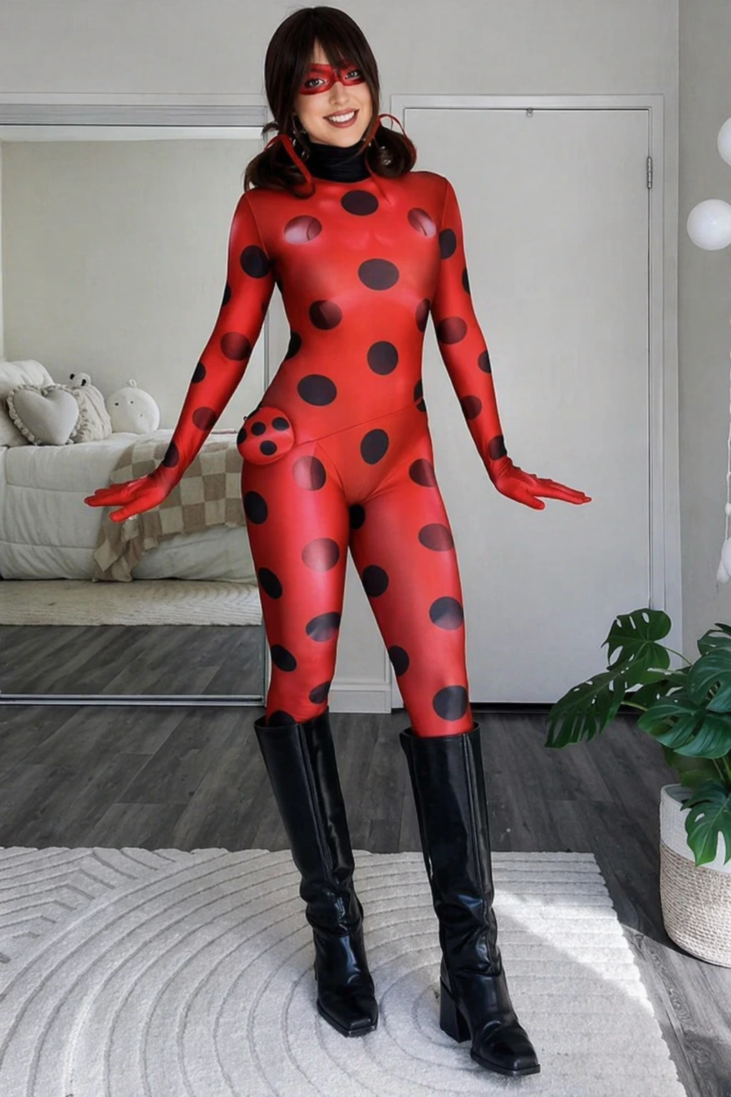 Woman wears a glossy red ladybug bodysuit with black spots, matching mask, black gloves, and tall boots.