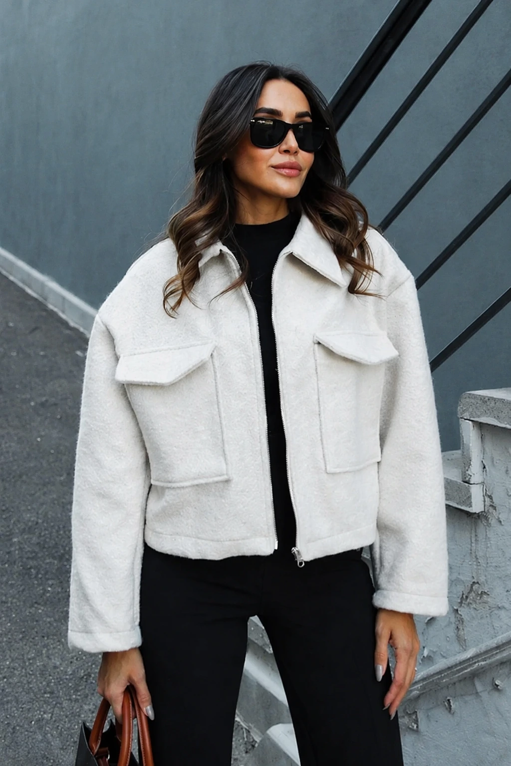 White fleece jacket with black turtleneck and black wide-leg trousers